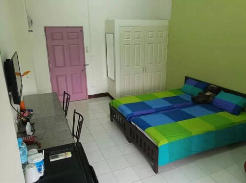 a bedroom with a bed and a pink door at Bannluangsiri บ้านหลวงสิริ in Ban Khlong Nung