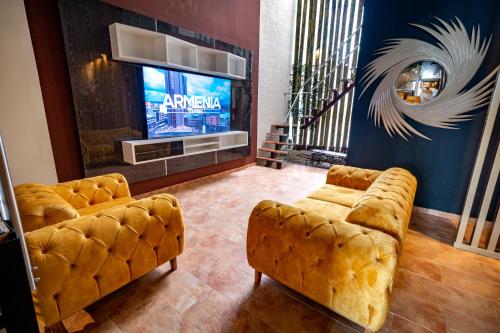 a living room with two couches and a television at Hotel Trugo Boutique Armenia in Armenia