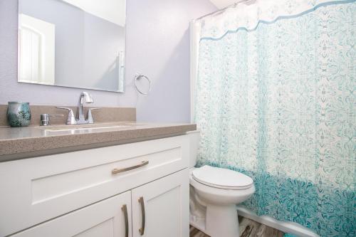 łazienka z toaletą i zasłoną prysznicową w obiekcie NV Best w mieście Boulder City