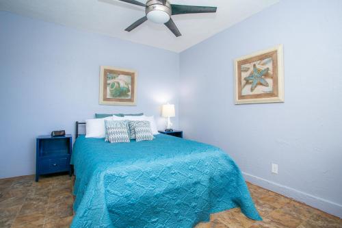 um quarto com uma cama azul e uma ventoinha de tecto em NV Best em Boulder City