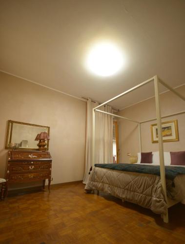 a bedroom with a canopy bed and a dresser at Villa Marisa in Pavia