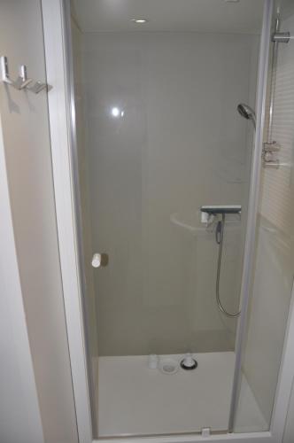 a shower with a glass door in a bathroom at Vacances de rêve entre pinèdes et océan in Gastes
