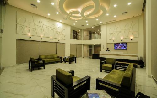 a lobby with couches and a flat screen tv at The Basil Park in Bhavnagar
