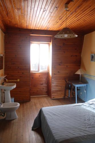 een slaapkamer met een bed, een wastafel en een raam bij Auberg'IN ! in La Salvetat-Peyralès