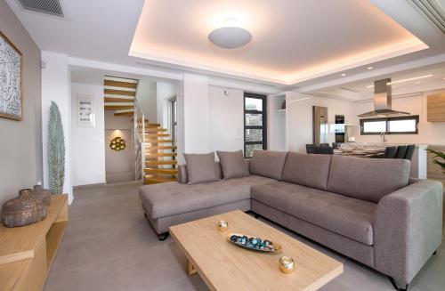 a living room with a couch and a table at Imperium Luxury Villas-Sauna, Jacuzzi, Heated Pool & Gym-Chania in Kato Galatas