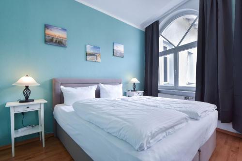 Un dormitorio con una cama grande con una pared azul. en Villa zur See - FeWo 10, en Heringsdorf