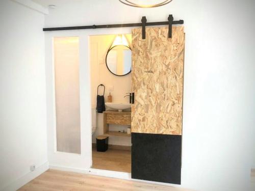 La salle de bains est pourvue d'un lavabo et d'un miroir. dans l'établissement Une maison design dans le centre ville, à Foix