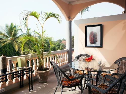 a balcony with a table and chairs and palm trees at RoofTop Boutique Hotel Adults Only in Serekunda