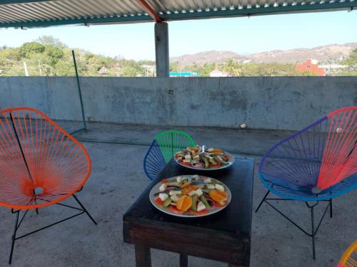 two plates of food on a table with chairs at Casa La Paz 3 in Puerto Escondido