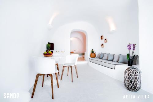 a white living room with a couch and a table at Traditional Cave Villas with Jacuzzi, Terrace and Sea view - Sando in Vourvoulos