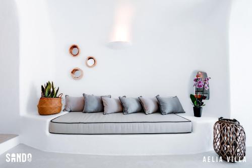 a white living room with a white couch at Traditional Cave Villas with Jacuzzi, Terrace and Sea view - Sando in Vourvoulos