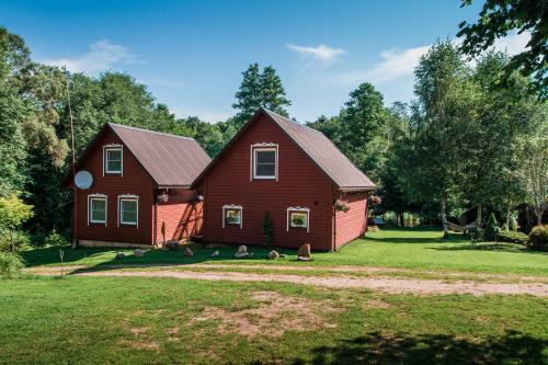 a red house with a red gambrel at Taparynė in Alanta