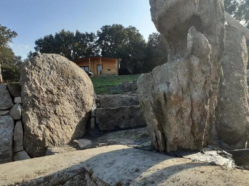 a group of rocks with a building in the background at Eco Lodge nella natura Con Piscina privata "La Grande Quercia" in Calangianus