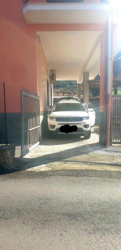a white car parked under a building with a garage at casa vacanza cilento PARDALIS in Agropoli