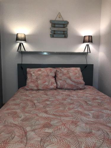 - une chambre avec un lit et deux lampes murales dans l'établissement Appartement cosy 100m plage de Pentrez, à Saint-Nic