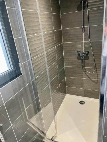 une douche avec une porte vitrée dans une salle de bain dans l'établissement Villa La Baronne-Hauteurs de Beaulieu-sur-Dordogne, à Beaulieu-sur-Dordogne