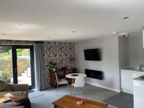 a living room with a couch and a table and a kitchen at Room with a View in Holmfirth