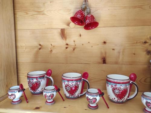 a shelf with four red and white cups and spoons at Apartment mit Traumblick im Haus Olympia in Grächen