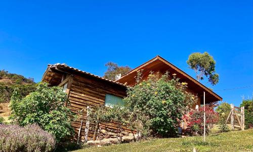 een blokhut met een hek ervoor bij Abrigo de montanha - Berghütte in São Bento do Sapucaí