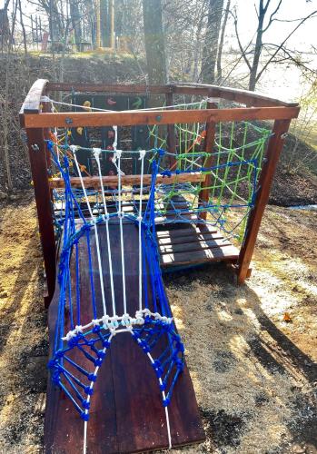 a wooden bench with a blue net on it at Baltās anemones in Jumprava