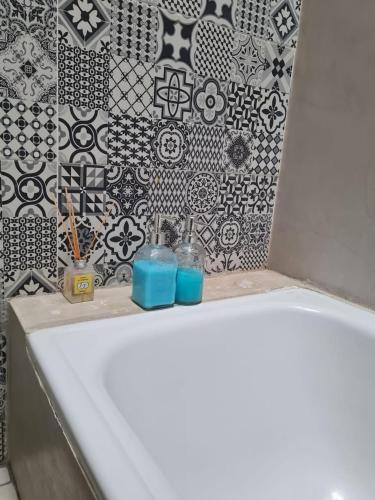 a bathroom with a white sink and black and white tiles at Lechuza del Campanario in San Antonio de Areco