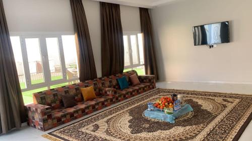 a living room with a couch and a television at استراحة السهيلي بديه in Al Ghabbī