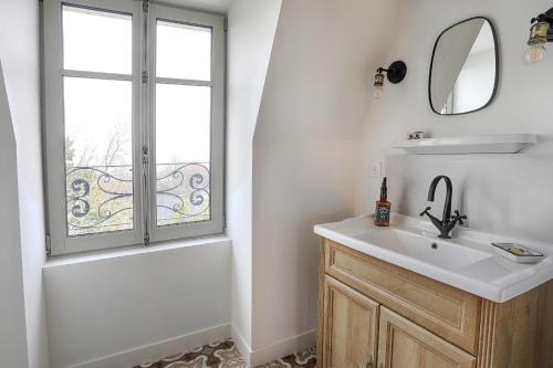 La salle de bains est pourvue d'un lavabo, d'une baignoire et d'une fenêtre. dans l'établissement Résidence L'Aristide Appartement Gustave, à Auray