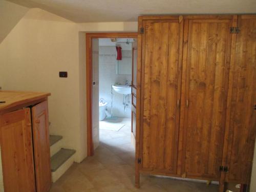 a kitchen with a large wooden closet and a bathroom at Chalet Borney in Fontainamore