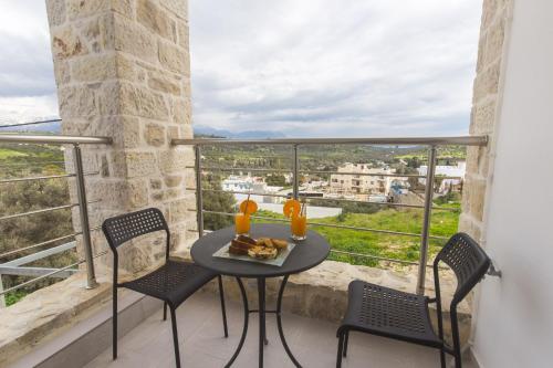 a table and chairs on a balcony with a view at Rafaela holiday home in Pitsidia