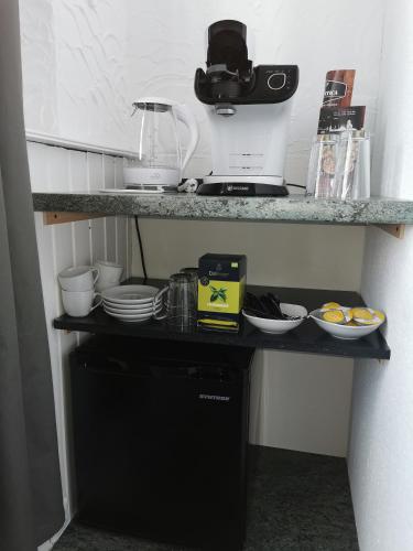 a kitchen with a counter with dishes on a shelf at Pension Zur Alten Post in Havelberg