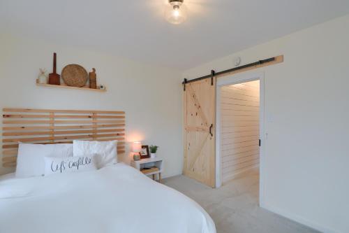 een slaapkamer met een wit bed en een houten deur bij Sweet Home 4 min to Cloister & Ephrata Center in Ephrata