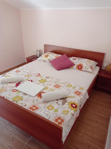 a bedroom with a large bed with flowers on it at Apartman Mia Mare in Kraj