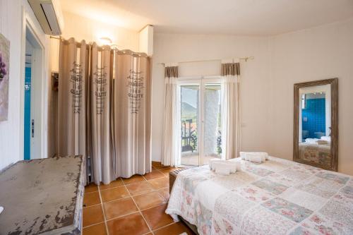 a bedroom with a bed and a large window at BGItalianVacation - Ville Li Conchi in Castiadas