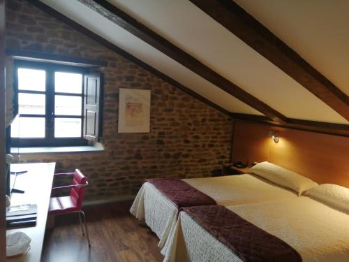 a bedroom with a bed and a window at Posada Real de Las Misas in Puebla de Sanabria