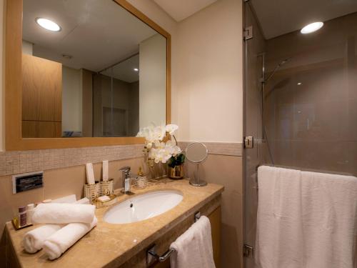 La salle de bains est pourvue d'un lavabo et d'une douche. dans l'établissement FIRST CLASS 2BR with full DUBAI SKYLINE & SEA view, à Dubaï