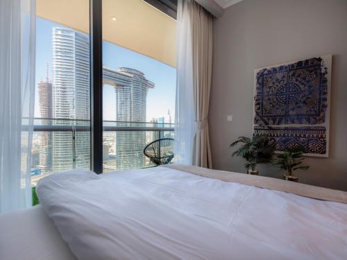 - une chambre avec un grand lit et une grande fenêtre dans l'établissement FIRST CLASS 2BR with full DUBAI SKYLINE & SEA view, à Dubaï