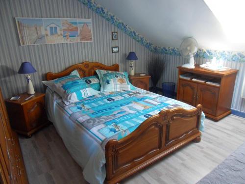 ベルク・シュル・メールにあるL Imperatriceのベッドルーム1室(大型木製ベッド1台、青い枕付)