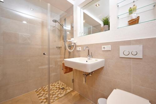 a bathroom with a shower and a sink and a toilet at Ferienhaus Alpinissimo in Oberammergau