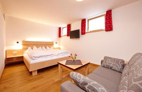 a bedroom with a bed and a living room at Ferienhaus Alpinissimo in Oberammergau