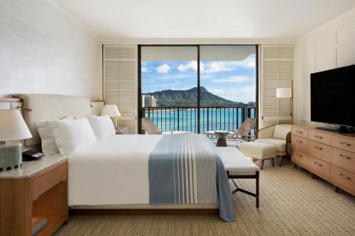 a hotel room with a large bed and a television at Halekulani - NO RESORT FEE in Honolulu