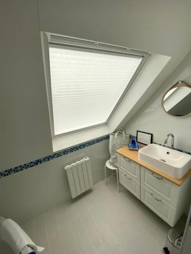 une salle de bain avec un lavabo et une fenêtre dans l'établissement Maison spacieuse à deux pas de la plage …, au Palais