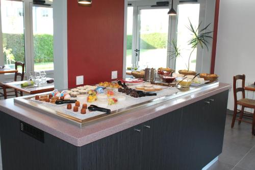 a buffet line with food on it in a kitchen at Brit Hotel Mayenne in Mayenne