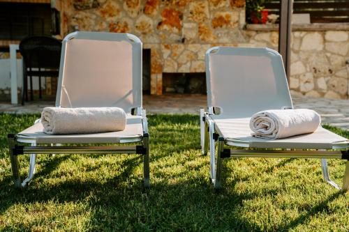 two chairs sitting on the grass in the yard at Villa Rena in Sivota