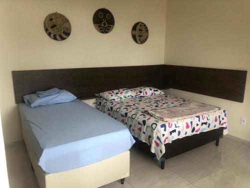 1 dormitorio con 2 camas y 2 relojes en la pared en Lindo APARTAMENTO com Varanda à 100m - Praia de BOA VIAGEM, en Recife