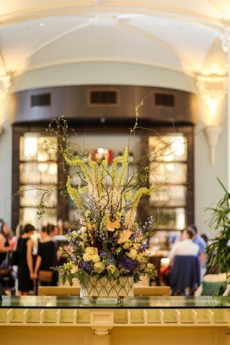 a vase of flowers on a table in a room at NOPSI Hotel New Orleans in New Orleans