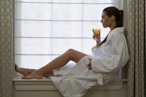a woman sitting on a window sill holding a drink at NOPSI Hotel New Orleans in New Orleans