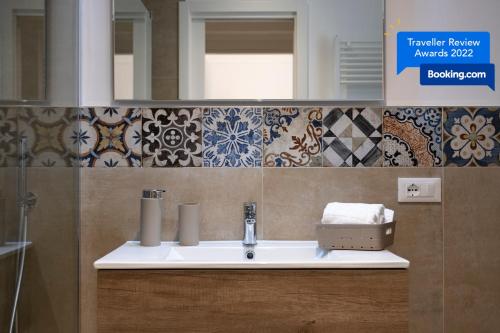 a bathroom with a sink and a mirror and tiles at CASA ELISA in Monopoli