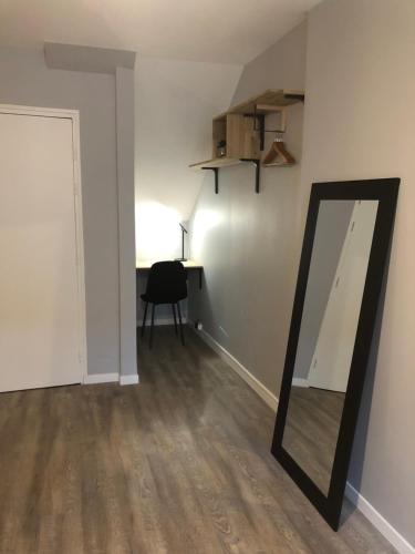 a mirror in a room with a chair and a desk at Cocon Cosy Nancy centre in Nancy