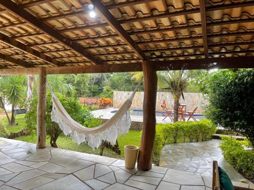 a hammock hanging under a pergola in a garden at chacara sombra da mata01 in Pirenópolis