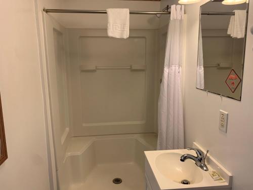 a white bathroom with a sink and a shower at HAVEN INN in Glendale